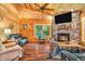 Cozy living room showcasing a stone fireplace, wooden walls, and comfortable seating at 2780 W Grizzly Trl, Martinsville, IN 46151