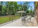 Wooden back deck with a metal table and chairs overlooks the backyard and detached garage at 2905 N Warman Ave, Indianapolis, IN 46222