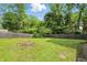 Spacious backyard featuring a green lawn, mature trees, and a wooden privacy fence at 2905 N Warman Ave, Indianapolis, IN 46222