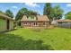 Exterior view of a two-story home with a large backyard featuring mature trees and green grass at 2905 N Warman Ave, Indianapolis, IN 46222