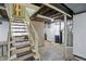 View of the unfinished basement with a washing machine, utility equipment, and a staircase at 2905 N Warman Ave, Indianapolis, IN 46222