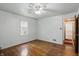 Another view of bedroom showcasing hardwood floors and natural light, with a glimpse into the hallway at 2905 N Warman Ave, Indianapolis, IN 46222