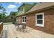 Rear exterior view of brick home featuring a wooden deck, lush landscaping and blue skies at 2905 N Warman Ave, Indianapolis, IN 46222