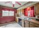 Traditional kitchen with oak cabinets, neutral countertops, and red walls and curtains at 2905 N Warman Ave, Indianapolis, IN 46222