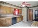 Traditional kitchen with oak cabinets, neutral countertops, and a vintage red ceiling fan at 2905 N Warman Ave, Indianapolis, IN 46222