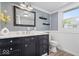 Modern bathroom with a dark vanity, marble countertop, framed mirror, and a stylish color palette at 301 S Main St, Whitestown, IN 46075