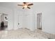 Bright bedroom featuring white walls, a ceiling fan, and two closets, creating a serene and inviting space at 301 S Main St, Whitestown, IN 46075
