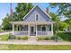 Charming home featuring a cozy front porch with white railings and manicured landscaping at 301 S Main St, Whitestown, IN 46075