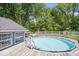Inviting in-ground pool surrounded by a wooden deck and lush greenery, perfect for outdoor enjoyment at 301 S Main St, Whitestown, IN 46075