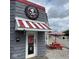 Charming pizzeria exterior featuring a red-striped awning and a picnic table for outdoor dining at 301 S Main St, Whitestown, IN 46075