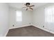 This bedroom features neutral walls, a ceiling fan, gray carpet and natural light from two windows at 3035 N Capitol Ave, Indianapolis, IN 46208