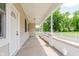 Inviting front porch with white columns, concrete flooring, white door and view of lush landscaping at 3035 N Capitol Ave, Indianapolis, IN 46208