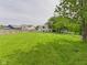 Expansive backyard featuring lush green grass, mature trees, and ample space for recreation at 3223 Keystone Lakes Way, Indianapolis, IN 46237