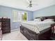 Cozy bedroom featuring blue walls, plush carpeting, a ceiling fan, and a large window with natural light at 3223 Keystone Lakes Way, Indianapolis, IN 46237