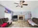 Cozy living room with a brick fireplace, ceiling fan, and natural light from the stained glass window at 3223 Keystone Lakes Way, Indianapolis, IN 46237