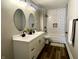 Elegant bathroom with dual sinks, modern fixtures, updated tiling in shower, and stylish mirrors at 3227 Guilford Ave, Indianapolis, IN 46205