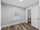 Bedroom with wood-look flooring, neutral walls and trim, closet and window at 3227 Guilford Ave, Indianapolis, IN 46205