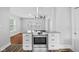 Open concept kitchen with stainless steel stove, granite countertops, and modern vent hood at 3227 Guilford Ave, Indianapolis, IN 46205