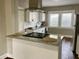 Modern kitchen features a granite island, stainless steel hood, white cabinets and updated appliances at 3227 Guilford Ave, Indianapolis, IN 46205