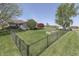 Fenced backyard featuring mature trees, green lawn, and raised planting beds at 407 N Matthews Rd, Greenwood, IN 46143