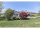 Landscaped backyard with patio, grill, dining set, mature trees and manicured lawn at 407 N Matthews Rd, Greenwood, IN 46143