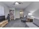 Finished basement recreation area with neutral carpet, ceiling fan, bookshelves and seating at 407 N Matthews Rd, Greenwood, IN 46143