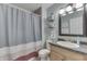 Full bathroom with a gray shower curtain and wood cabinets at 407 N Matthews Rd, Greenwood, IN 46143