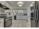 Well-lit kitchen with white cabinetry, granite countertops, and modern appliances, showcasing style and functionality at 407 N Matthews Rd, Greenwood, IN 46143