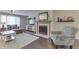 Inviting living room featuring a cozy fireplace, patterned armchair, hardwood floors and a textured rug at 407 N Matthews Rd, Greenwood, IN 46143