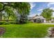 Spacious backyard with mature trees, a well-manicured lawn, and a detached garage at 5165 E Pleasant Run Pkwy S Dr, Indianapolis, IN 46219