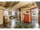 Spacious basement with painted walls, utility connections, tool chest, and a door leading to the bathroom at 5165 E Pleasant Run Pkwy S Dr, Indianapolis, IN 46219