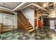 Staircase leading to a basement with utility connections, painted walls, and tool storage at 5165 E Pleasant Run Pkwy S Dr, Indianapolis, IN 46219