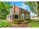 Beautiful brick home featuring a screened porch, mature landscaping, and a classic architectural style at 5165 E Pleasant Run Pkwy S Dr, Indianapolis, IN 46219