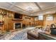 A cozy living room featuring wood paneling, a fireplace, a TV and a comfortable leather couch at 5165 E Pleasant Run Pkwy S Dr, Indianapolis, IN 46219