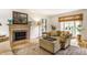 Bright living room with fireplace, plush seating, and large windows featuring woven shades at 5165 E Pleasant Run Pkwy S Dr, Indianapolis, IN 46219