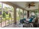 Relaxing screened-in porch with comfortable seating, ceiling fan, and views of the backyard garden at 5165 E Pleasant Run Pkwy S Dr, Indianapolis, IN 46219