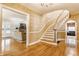 Elegant staircase featuring hardwood floors, decorative wallpaper, and classic design at 5165 E Pleasant Run Pkwy S Dr, Indianapolis, IN 46219