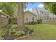 Backyard featuring a wooden patio with dining set bordered by landscaped garden at 5259 Broadway St, Indianapolis, IN 46220
