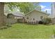 Outdoor dining and backyard area with green lawn, wood fence, and outdoor grill at 5259 Broadway St, Indianapolis, IN 46220