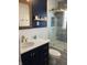 Charming bathroom featuring a vanity with gold fixtures, a glass shower, and beautiful blue patterned tiles at 5259 Broadway St, Indianapolis, IN 46220