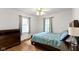 Cozy bedroom featuring hardwood floors, a large bed, and natural light from two windows at 5259 Broadway St, Indianapolis, IN 46220