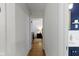 Bright hallway leading to a bedroom and bathroom, showcasing hardwood floors and fresh, neutral walls at 5259 Broadway St, Indianapolis, IN 46220