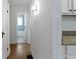 Hallway with hardwood flooring leading to the bathroom, featuring tile accents and neutral colored paint at 5259 Broadway St, Indianapolis, IN 46220
