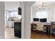 View of the home office featuring natural lighting and adjacent kitchen with white cabinets at 5259 Broadway St, Indianapolis, IN 46220