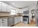 Bright kitchen featuring white cabinets, updated appliances, and a view to the adjacent room at 5259 Broadway St, Indianapolis, IN 46220