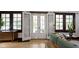 Bright living room featuring hardwood floors, an open double door, and a comfortable green sofa at 5259 Broadway St, Indianapolis, IN 46220