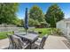 Outdoor dining set on patio with umbrella in a large, green backyard at 5333 Ralston Ave, Indianapolis, IN 46220