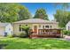 Charming bungalow-style home featuring a cozy front deck, well-maintained lawn, and colorful flower planters at 5333 Ralston Ave, Indianapolis, IN 46220