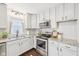 Bright kitchen boasts stainless steel appliances, granite countertops, and classic white cabinetry at 5333 Ralston Ave, Indianapolis, IN 46220