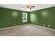 Spacious bedroom with a window, neutral carpet and complemented by green painted walls at 5369 Red River Ct, Indianapolis, IN 46221